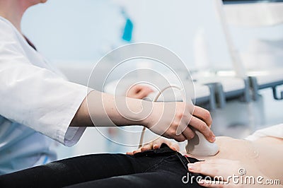 Close-up Of Doctor Moving Ultrasound Probe On Pregnant Woman`s Stomach In Hospital Stock Photo
