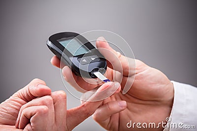 Doctor Checking Patient`s Sugar Level With Glucometer Stock Photo