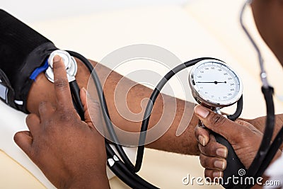 Doctor Measuring Blood Pressure Of Patient Stock Photo