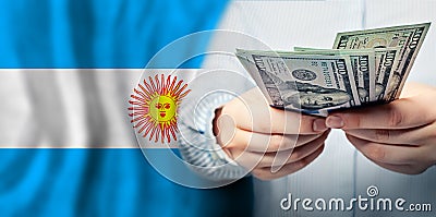 Close up dollars cash money in hand on flag of Argentina background Stock Photo