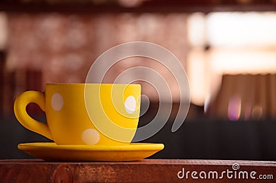 Close up of dotted yellow cup on the table Stock Photo