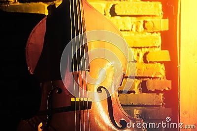 Close-up of double bass on a brick wall background in a club basement, underground jazz music Stock Photo