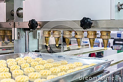 Close up dough or cream and nozzle discharge of automatic biscuit or sweets making machine in production line for high technology Stock Photo