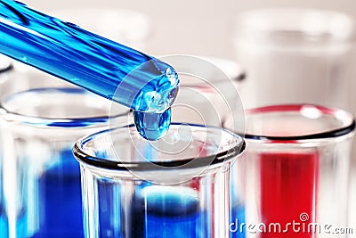 Close-up of a drop of liquid on a pipette falling into a test tube. Stock Photo