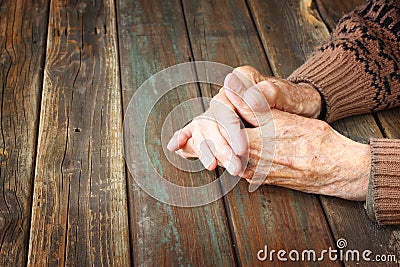 Close up of elderly male hands on wooden table Stock Photo