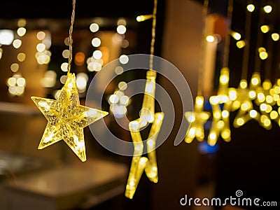 Close up of electric lighted stars with warm yellow lights against a dark backdrop. Festive / holiday mood concept Stock Photo