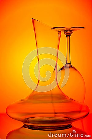 Close up of elegant curved crystal wine decanter and glass on colorful background Stock Photo