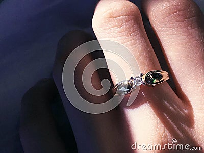 Close up of elegant diamond ring on the finger with gray Scarf background. Diamond ring. Stock Photo