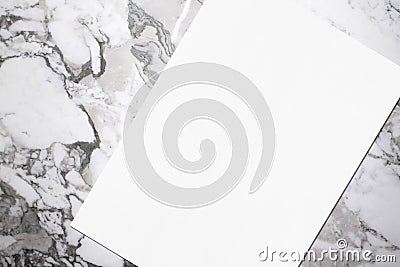 Close up of empty white rectangle poster mockup lying diagonally on grey marble background Stock Photo
