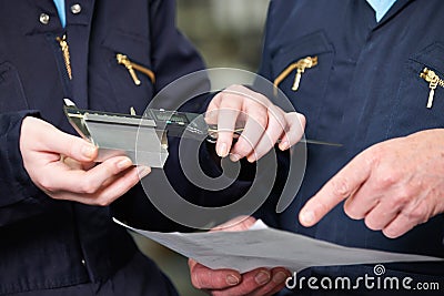 Close Up Of Engineers Measuring Component With Micrometer Stock Photo