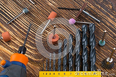 Close-up, engravings with nozzles, next to a set of all sizes of drills, on a dark wooden background Stock Photo