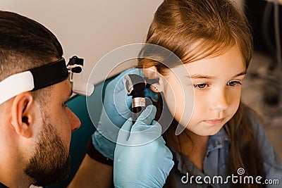 Close-up examination of childs ear with otoscope. Otoscopy. Visit to ENT doctor and consultation. Stock Photo
