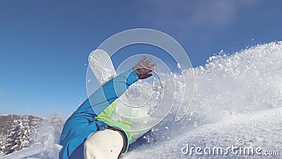 CLOSE UP: Extreme male cross country snowboarder crashes into fresh snow Stock Photo