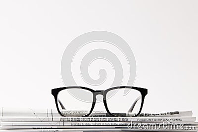 close up of eyewear on pile of newspapers, on white background with copy space Stock Photo