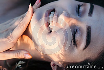 Close-up face of beautiful girl lying on the grass , young woman with long hair on nature,summer tender photo in village Stock Photo