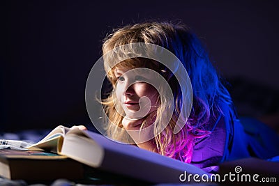 Close up face of child reading a books. Kids bedtime, boy reading a book in bed. Stock Photo