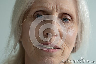 Close-up of the face of an elderly woman with gray hair, looking at the camera Stock Photo