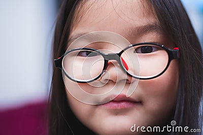 Close-up of the face of a girl wearing glasses to help her see from nearsightedness Stock Photo