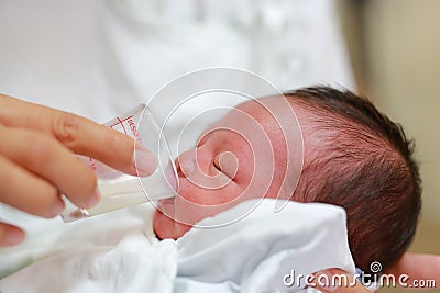 Close-up face of infant drinking milk from glass cup Stock Photo