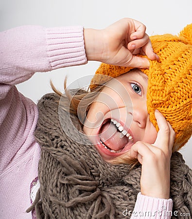 Close up face portrait of toothy smiling young woman wearing knitted hat and scarf. Stock Photo