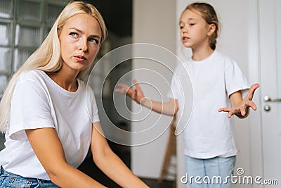 Close-up face of unhappy despair pensive young mother sitting on sofa listening mad little child daughter scolding Stock Photo