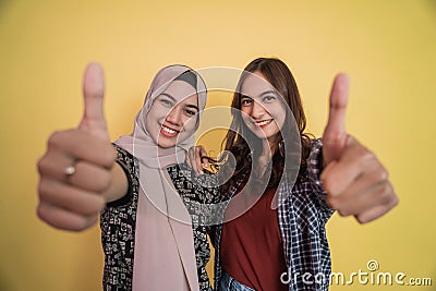 close up of faces of two smiling women looking at camera with thumbs up gesture Stock Photo