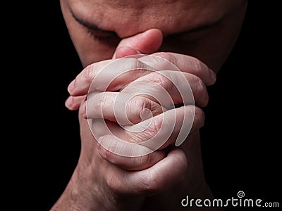 Close up of faithful mature man praying, hands folded in worship to god Stock Photo