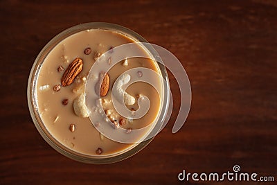 Close up of a famous Bengali dessert `Nolen Gurer Chanar Payesh` or Milk pudding of cottage cheese in a glass bowl. Top-down view Stock Photo