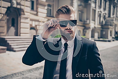 Close up of a famous guy in formal wear and sunglasses outdoors. Stock Photo