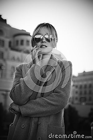 Beautiful girl standing at the street in wearing sunglasses Stock Photo