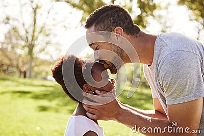 Close Up Of Father Kissing Daughter In Park Stock Photo