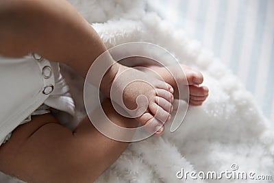 Close Up Of Feet Of Newborn Baby In Nursery Cot Stock Photo