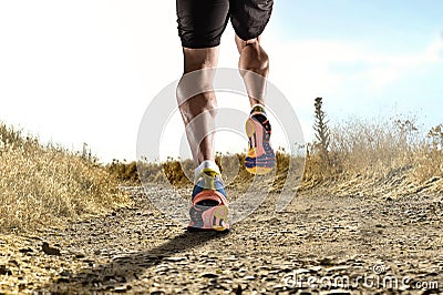 Close up feet with running shoes and strong athletic legs of sport man jogging in fitness training workout Stock Photo