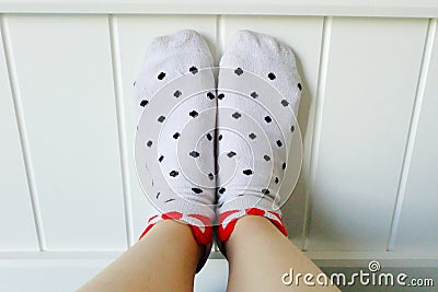 Close Up Feet Wearing White Polka Dot Socks in Bedroom Background Stock Photo