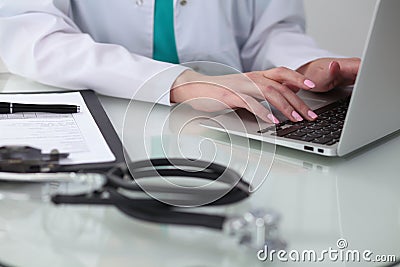 Close-up of female doctor hands typing on laptop computer. Physician at work. Medicine, healthcare and help concept Stock Photo