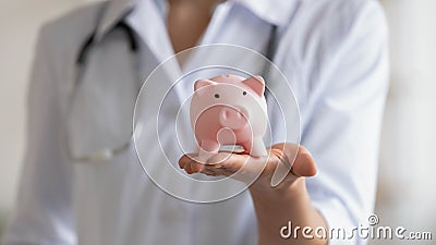 Close up of female doctor hold piggybank collect donation Stock Photo
