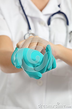 Close up of a female doctor putting a green latex gloves Stock Photo