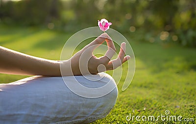 A woman meditating outdoor. Yoga lotus pose Stock Photo