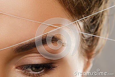 Eyebrow threading - epilation procedure for brow shape correction Stock Photo