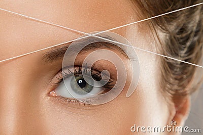 Eyebrow threading - epilation procedure for brow shape correction Stock Photo