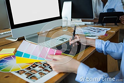 Close-up of female graphic designer using graphics tablet at desk Stock Photo