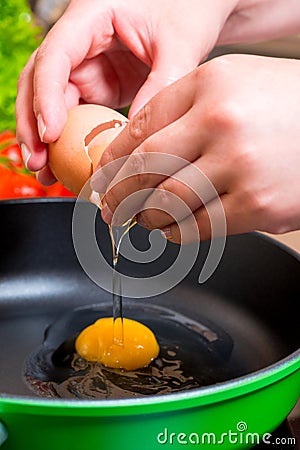 Close up of female hands breaking eggs Stock Photo