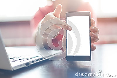 Close up of female hands holding blank smartphone, pointing a finger at the copy space screen for your advertisement. A woman work Stock Photo