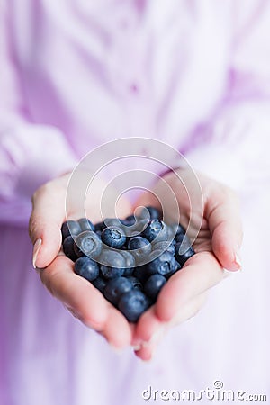 Close up of female hands holding tasty ripe blueberries Stock Photo
