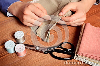 Close-up female hands sewing fabric on old wooden table Stock Photo