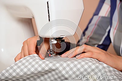 Close-up female hands sewing fabric on sewing machine Stock Photo