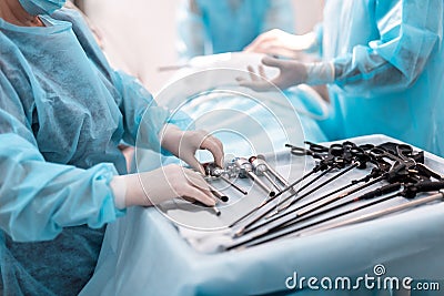 Nurse standing near table with laparoscopic instruments Stock Photo