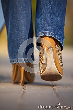 Close-up of female in jaguar spotted shoes walking Stock Photo