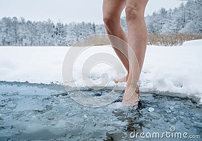 Close up of female legs getting into ice cold water Stock Photo