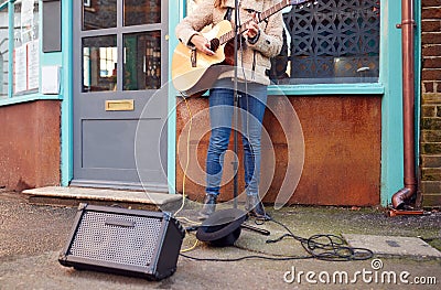 Close Up Of Female Musician Busking Playing Acoustic Guitar Outdoors In Street Stock Photo